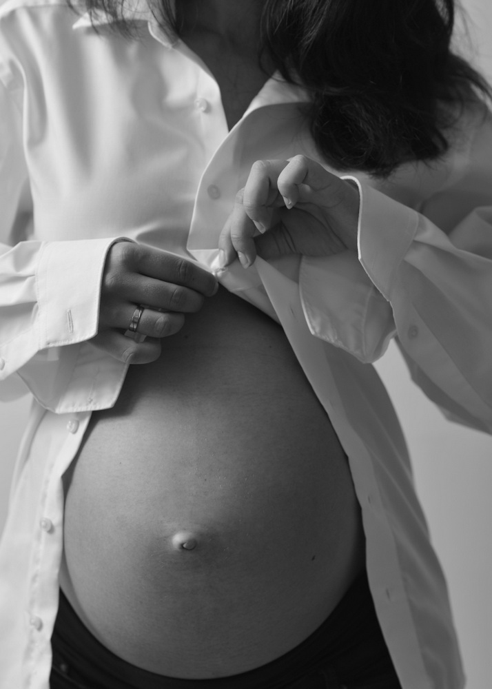 Wunderschöne Babybauch Fotografie im Studio und outdoor Eine werdende Mutter liebevoll dargestellt mit Ihrem Babybauch im warmen Studiolicht