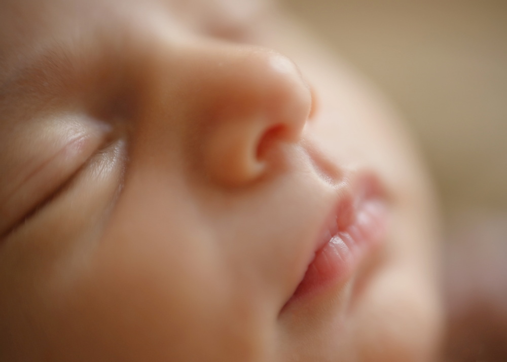 Fotograf Neugeborene Erfurt – Voigt Fotografie Ein friedlich schlafendes neugeborenes Baby beim Baby-Fotoshooting in Erfurt - Detailaufnahme Mund