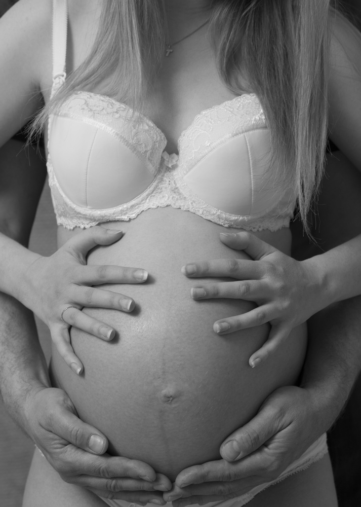 Wunderschöne Babybauch Fotografie im Studio und outdoor Eine werdende Mutter liebevoll dargestellt mit Ihrem Babybauch im warmen Studiolicht
