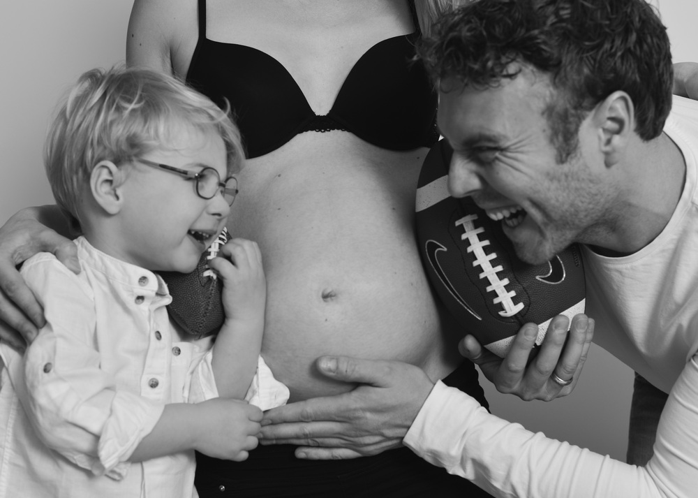 Wunderschöne Babybauch Fotografie im Studio und outdoor Eine werdende Mutter liebevoll dargestellt mit Ihrem Babybauch im warmen Studiolicht