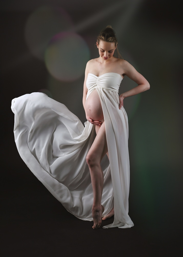 Wunderschöne Babybauch Fotografie im Studio und outdoor Eine werdende Mutter liebevoll dargestellt mit Ihrem Babybauch im warmen Studiolicht
