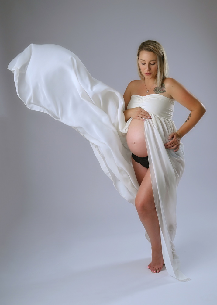 Wunderschöne Babybauch Fotografie im Studio und outdoor Eine werdende Mutter liebevoll dargestellt mit Ihrem Babybauch im warmen Studiolicht