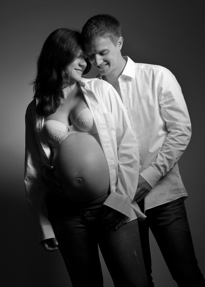 Wunderschöne Babybauch Fotografie im Studio und outdoor Eine werdende Mutter liebevoll dargestellt mit Ihrem Babybauch im warmen Studiolicht