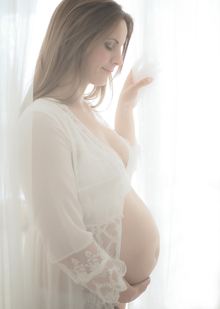 Wunderschöne Babybauch Fotografie im Studio und outdoor Eine werdende Mutter liebevoll dargestellt mit Ihrem Babybauch im warmen Studiolicht
