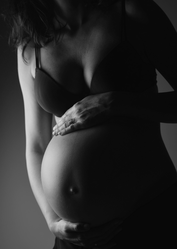Wunderschöne Babybauch Fotografie im Studio und outdoor Eine werdende Mutter liebevoll dargestellt mit Ihrem Babybauch im warmen Studiolicht