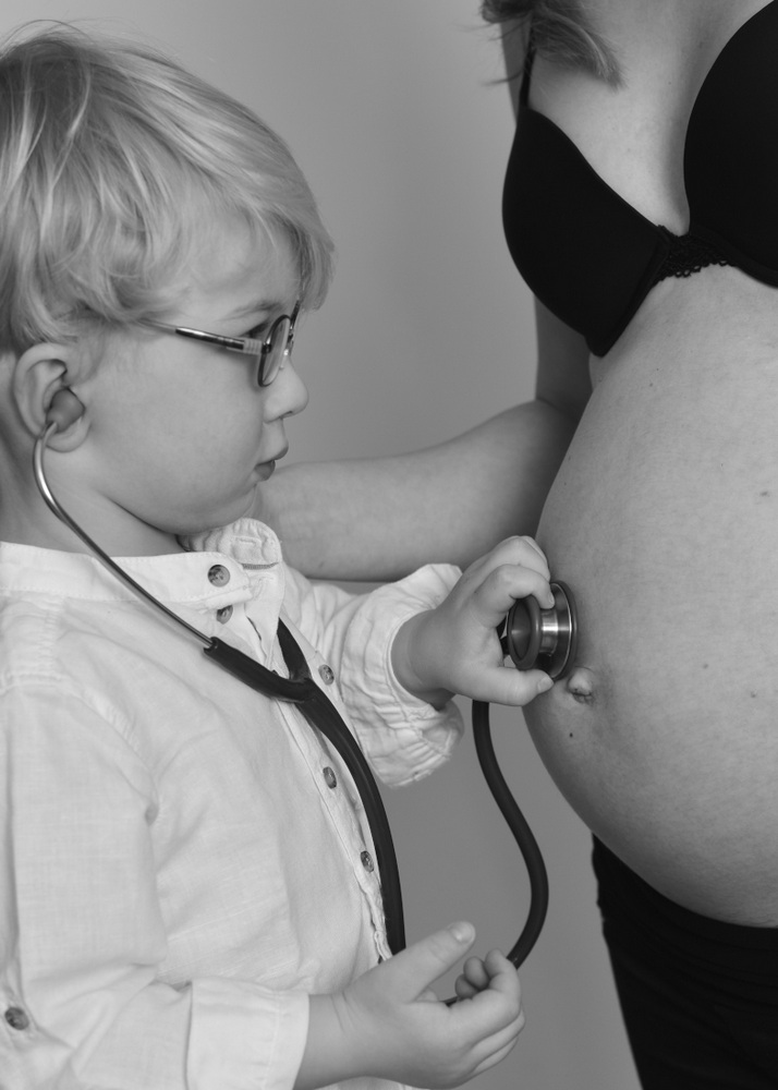Wunderschöne Babybauch Fotografie im Studio und outdoor Eine werdende Mutter liebevoll dargestellt mit Ihrem Babybauch im warmen Studiolicht